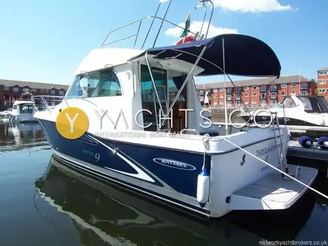Beneteau Antares 9: stern quarter view with blue bimini over cockpit, bathing platform and swimming ladder