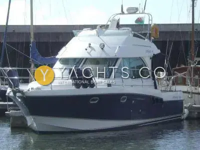 Beneteau Antares 980: starboard bow view of the navy-hulled cruiser moored in a marina, Welsh flag on the radar arch