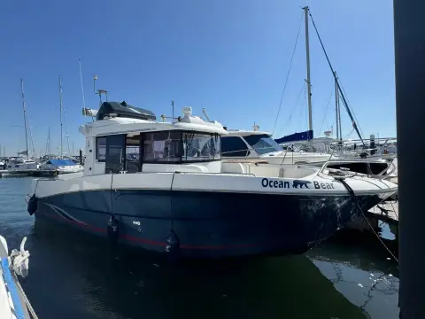 Beneteau Barracuda 9: starboard quarter view of the hull and flybridge moored at a marina