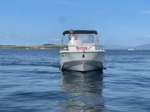 Beneteau Flyer 6 Space Deck: bow view of the boat at rest on calm water with bimini up