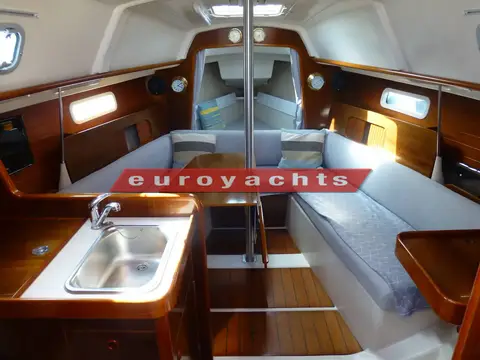 Beneteau Oceanis 281 Clipper: saloon looking forward past the galley sink to U-shaped seating and the forward cabin