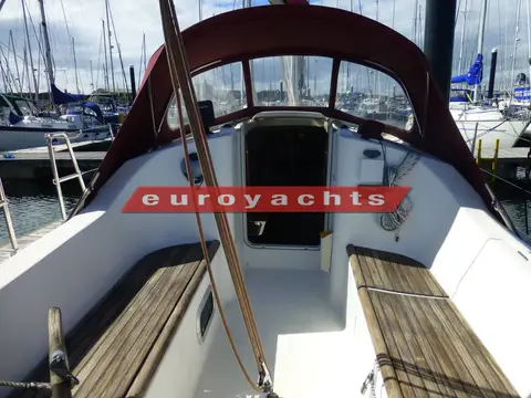Beneteau Oceanis 281 Clipper: cockpit with teak-slatted seats facing the companionway under the burgundy sprayhood