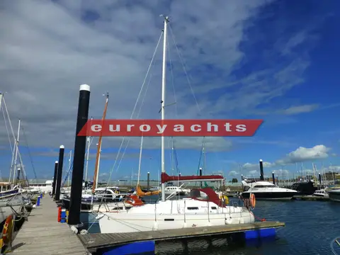 Beneteau Oceanis 281 Clipper: moored on a pontoon under blue sky with flags flying from the stern