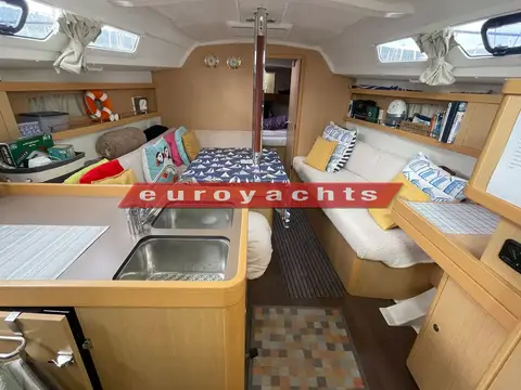 Beneteau Oceanis 34: saloon looking forward from galley, twin sinks, dining table and settee with cushions