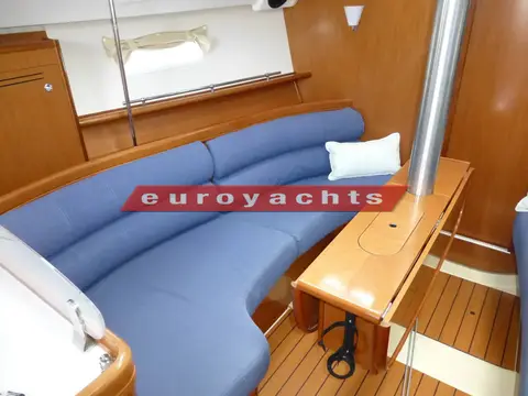 Beneteau Oceanis 343: curved blue settee in the saloon beside the folded dining table and mast support