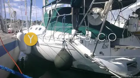 Beneteau Oceanis 351: hull side view in marina showing green canvas, stern frame and blue sky