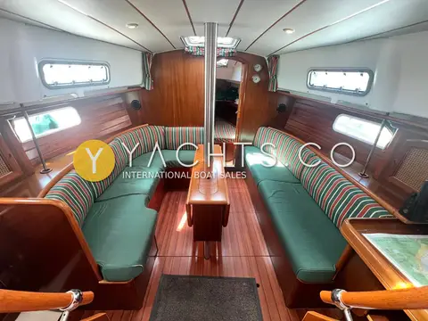 Beneteau Oceanis 36 CC: saloon with green upholstered settees, cherry joinery and central table
