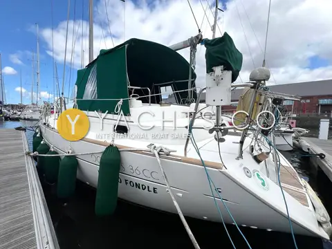 Beneteau Oceanis 36 CC: starboard bow and topsides with fenders and green enclosure, marina setting