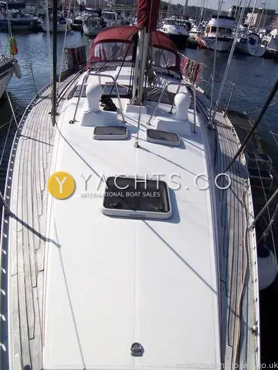 Beneteau Oceanis 390: white foredeck with hatch and anchor locker lid, teak side decks and marina beyond
