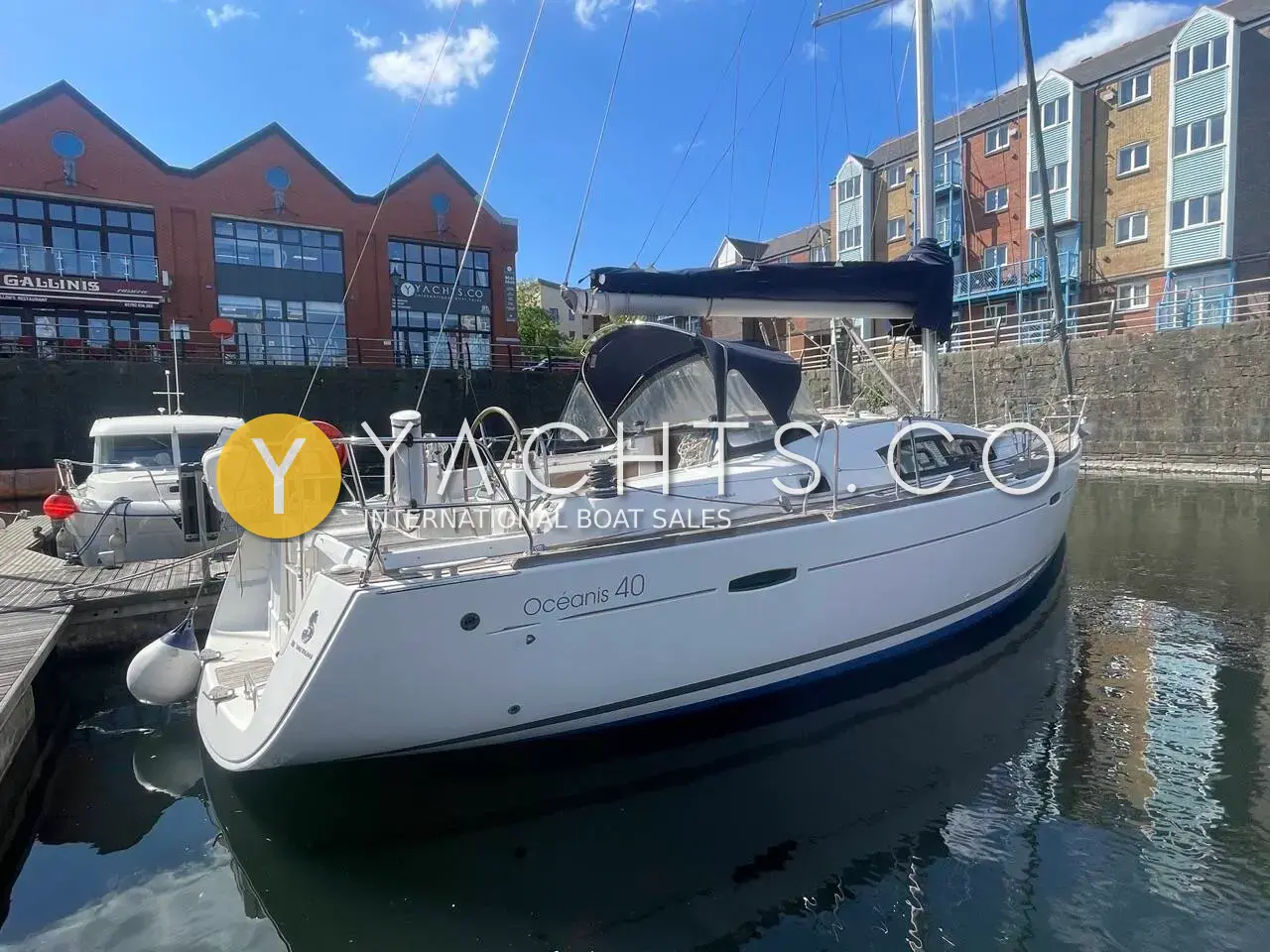 Beneteau Oceanis 40: white sloop moored stern-to in a marina basin with brick apartment buildings behind