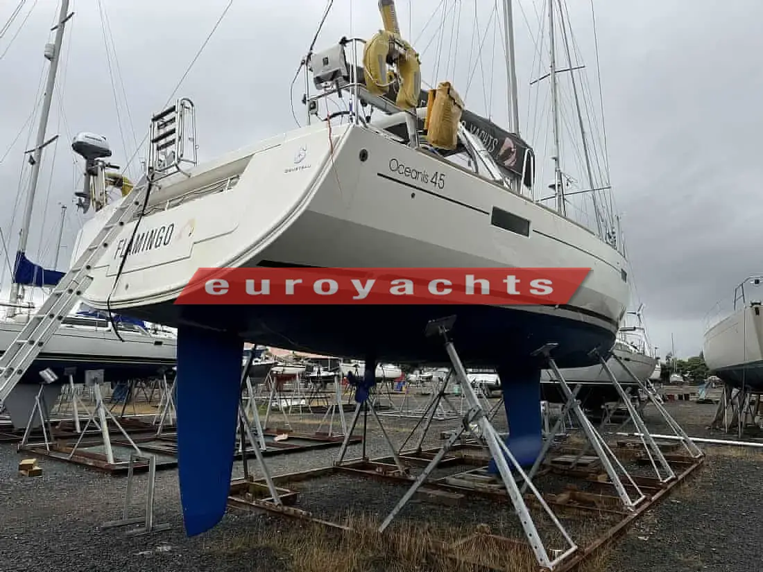 Beneteau Oceanis 45: hull ashore on stands in a boatyard, viewed from the stern quarter with blue keel