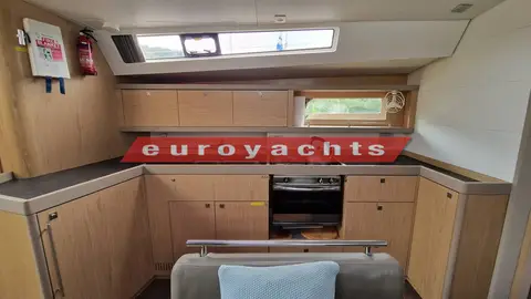 Beneteau Oceanis 45: galley with oven, sink and light wood cabinets beneath a long hull window