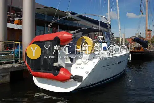 Beneteau Oceanis Clipper 343: stern view in a marina with red inflatable tender on davits and lifebuoy on pushpit