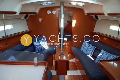 Beneteau Oceanis Clipper 343: saloon with blue upholstered seating, wood joinery, folding table and twin skylights