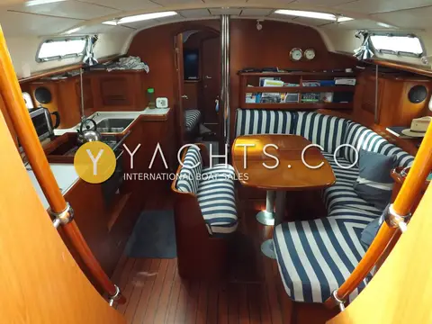 Beneteau Oceanis Clipper 411: wide view of saloon with blue and white striped U-shaped seating and galley to port