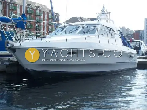 Birchwood Challenger 320: white hull named White Orchid moored stern-to in a marina beside brick apartments