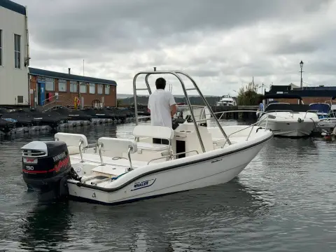 Boston Whaler Dauntless 18: starboard quarter view showing outboard on the transom and stainless arch over the helm