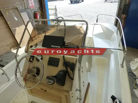 Boston Whaler Newport 17: helm console with steering wheel, chartplotter and VHF radio behind a grab rail