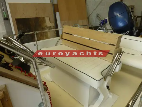 Boston Whaler Newport 17: helm bench seat with wooden slatted backrest and stainless grab rails