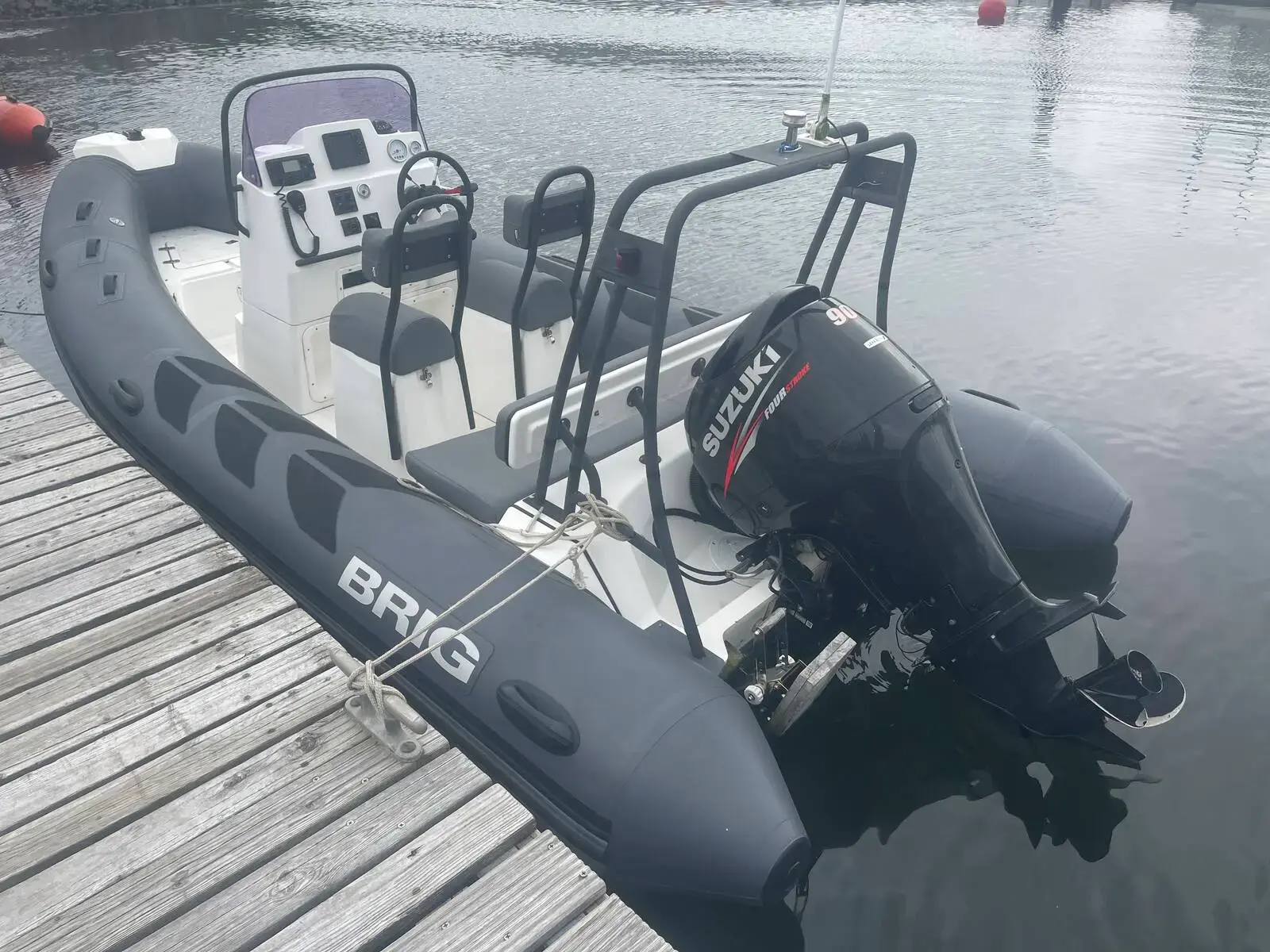 Brig RIBs Navigator 520: grey tubes, console with two jockey seats and stainless arch, Suzuki outboard, moored at pontoon