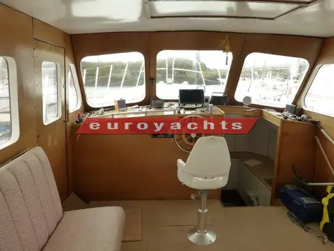 Bruce Roberts Waverunner 45: wheelhouse with central white helm seat, wooden console and wide forward windows