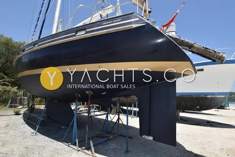 Contest 48CS: stern quarter ashore showing dark hull, gold stripe, rudder, propeller and swimming ladder