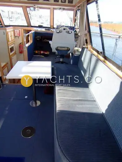 Cougar Advance 41 Boat For Sale: saloon looking forward along long blue settee to the starboard helm seat