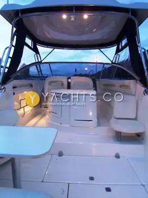 Cranchi 32 Zaffiro Reduced: cockpit at dusk under the hardtop with lights on, wet bar unit and fold-out table
