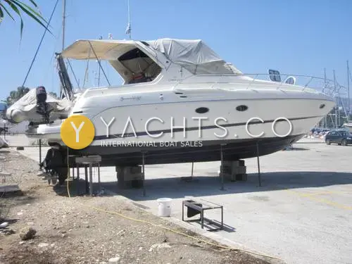 Cranchi 37 Smeraldo: starboard side on stands ashore with cockpit canopy fitted and tender on the bathing platform