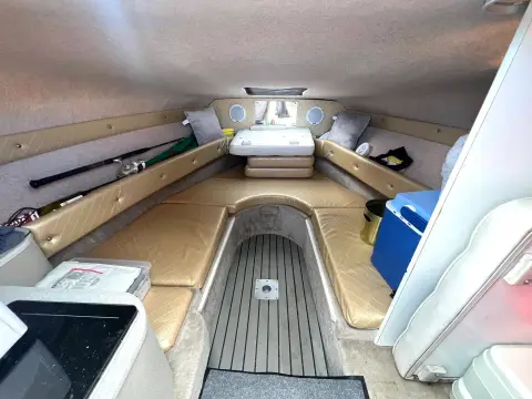 Crownline 210 CCR: forward cabin with U-shaped beige seating, cushions stowed and teak-effect sole
