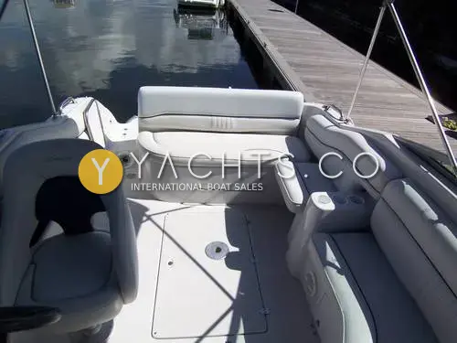 Crownline 230 CCR: cockpit with grey upholstered rear bench, helm seat and cup holders beside a pontoon