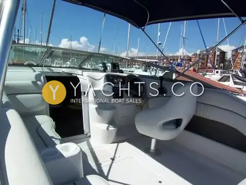 Crownline 230 CCR: cockpit under bimini looking forward to the helm, cabin door and marina beyond