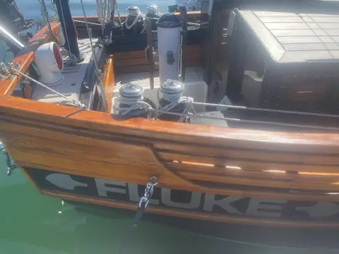 Unique Gaff Yawl: transom with varnished wood, carved name board, winches and outboard bracket above