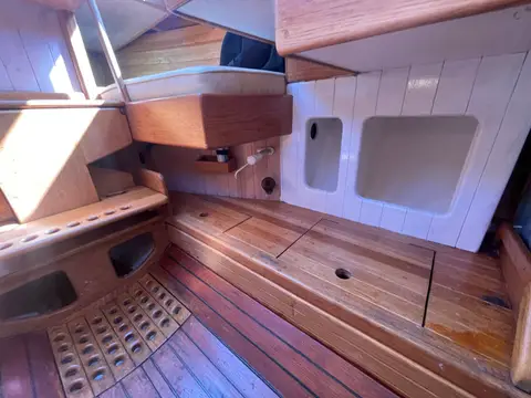 Unique Gaff Yawl: interior wooden lockers and seating with slatted floor and white panelled bulkhead