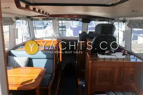 Cygnus Marine Cygnus Cyclone 26 Patrol Mk III: wheelhouse interior with blue saloon seating, varnished wood table and single helm seat