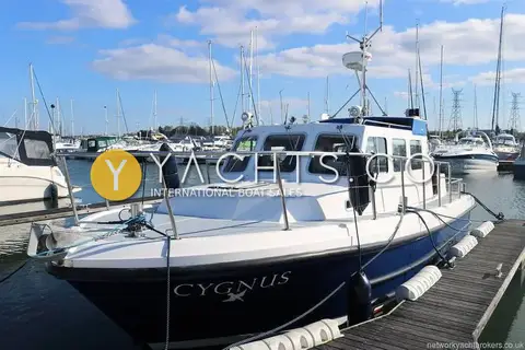 Cygnus Marine Cygnus Cyclone 26 Patrol Mk III: bow and wheelhouse moored at a marina pontoon, name on dark blue hull