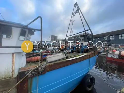 Cygnus Marine GM33: foredeck and bow mast seen from the wheelhouse side, with tyre fenders on the blue hull