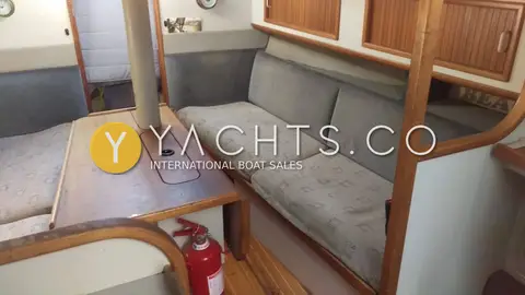 Dehler 34 Top Nova: starboard saloon settee with grey cushions, teak lockers above and folded table
