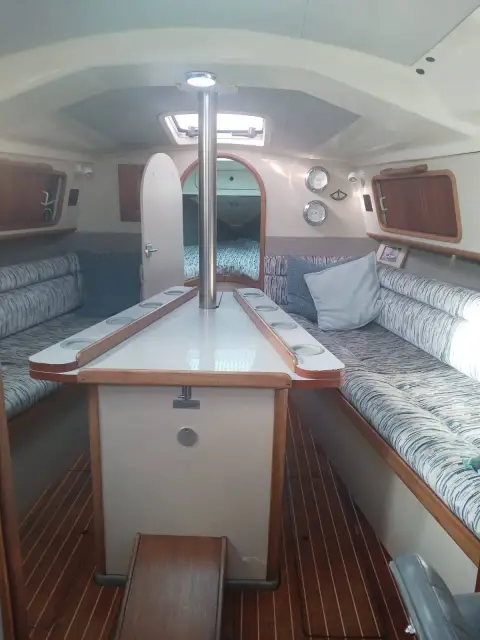Dehler 38 CWS: saloon looking forward to the forepeak, central table with fold-down leaves and patterned settees