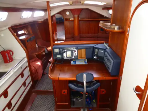 Dehler 43 CWS: chart table with instrument panel, looking forward through the warm wood saloon