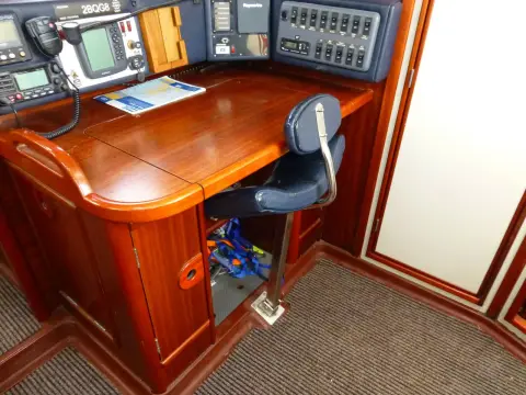 Dehler 43 CWS: chart table close-up showing hinged wooden seat, navigation instruments and switch panel