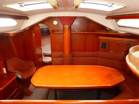 Dehler 43 CWS: saloon with polished wooden dining table, U-shaped seating and two overhead hatches