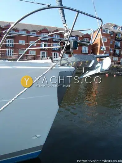 Elan Marine Elan Impression 434: bow with stainless steel pulpit and anchor on stem-head roller, red brick buildings behind