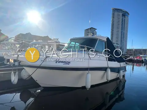 Faeton 630 Sport: starboard side of the white hull with fenders out, marina and tower in sunshine