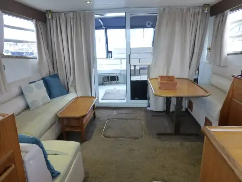 Fairline 50: saloon looking aft to sliding doors, cream settees, coffee table and dining table