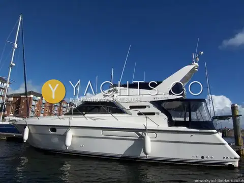 Fairline Phantom 41: port side profile showing flybridge, navy canopy and fenders on a marina pontoon