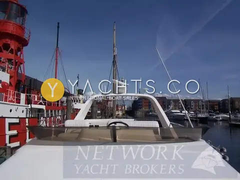 Fairline Phantom 41 Reduced: flybridge screen and radar arch, with a red lightship and marina buildings behind