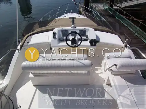 Fairline Phantom 41 Reduced: flybridge from aft, showing white upholstered seats, wheel and engine instruments