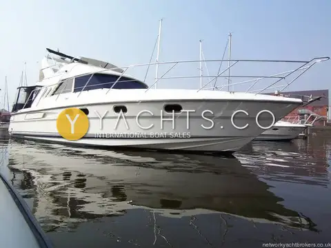 Fairline Phantom 41 Reduced: full starboard profile afloat with bow rails and calm water reflections in marina