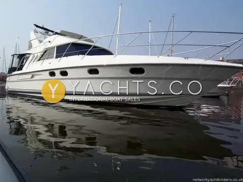 Fairline Phantom 41 Reduced: low starboard view of hull and flybridge reflected in still marina water